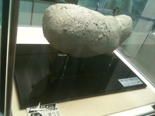 隣にあった「イトカワ」の模型。左手前に同縮尺の旅客機があり、大きさのイメージができます 隣にあった「イトカワ」の模型。左手前に同縮尺の旅客機があり、大きさのイメージができます