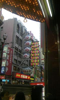 くいだおれから見た、ふぐ料理店づぼらや。かに道楽やくいだおれと並ぶ道頓堀の名物です。